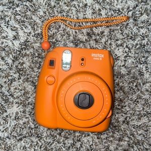 Orange Fujifilm instax 8 Polaroid camera. Bought in 2017. Still works